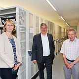 Drei Menschen stehen im Archiv der TU Clausthal