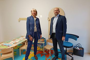 Zwei Personen stehen nebeneinander in einem Kinderzimmer