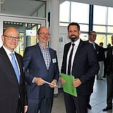 Menschen stehen nebeneinander in einer Halle